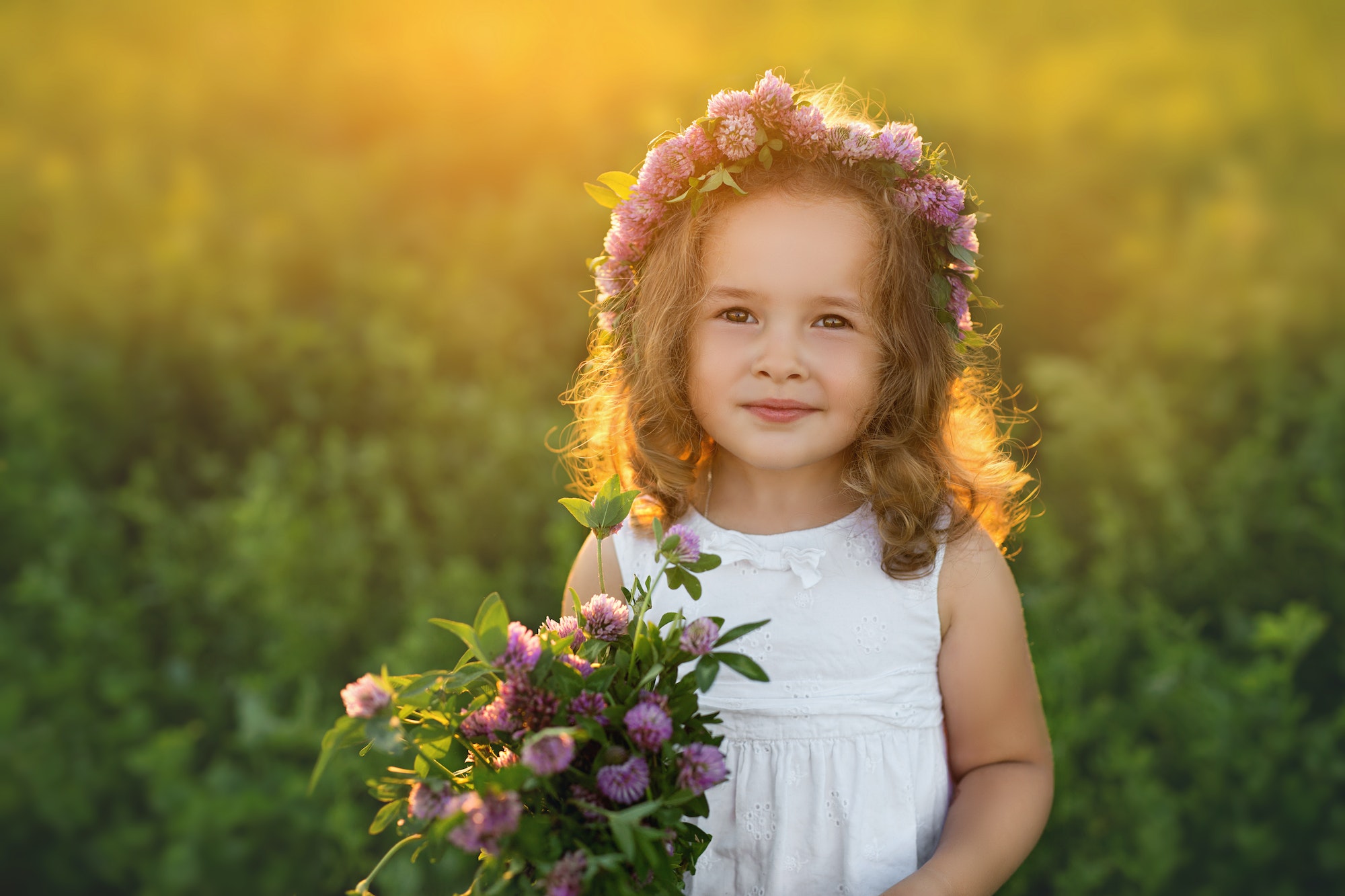 A bouquet of clover flowers in the hands of a child.