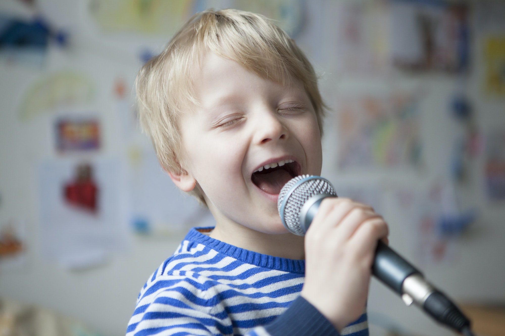 Portrait of singing little boy with microphone
